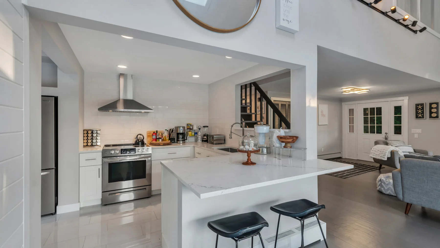 A bright open-plan kitchen and dining area with a large island and bar seating.