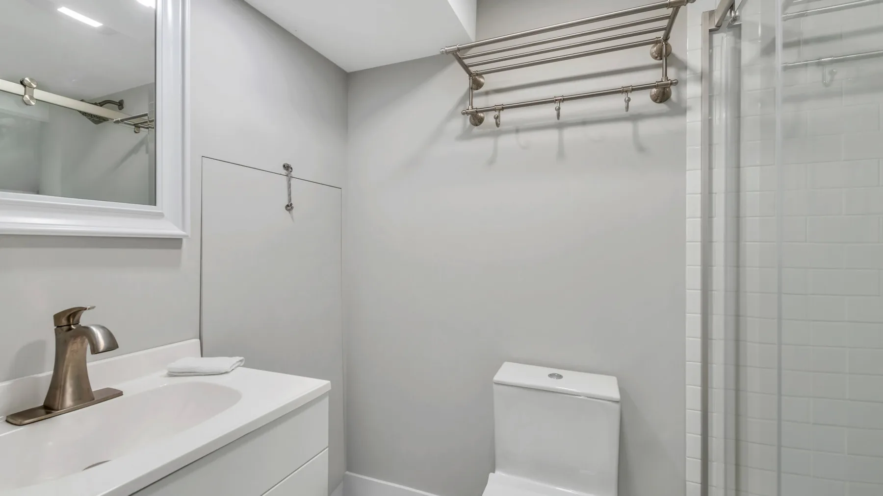 A bright bathroom with a sink, toilet, and shower.