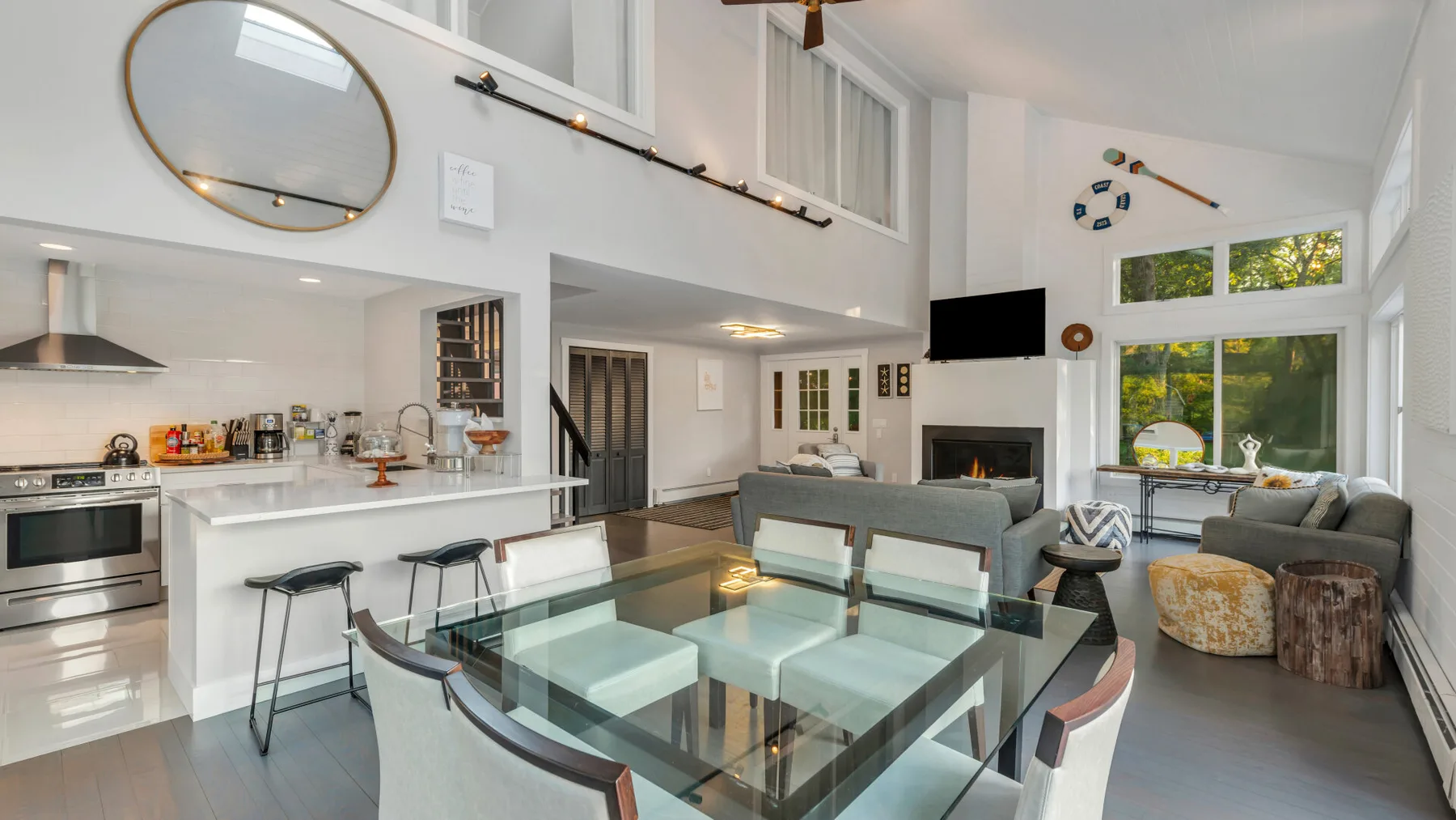 A bright open-plan living and dining area with glass table and seating.