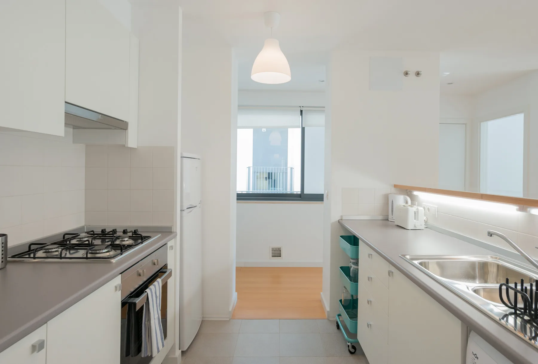A bright kitchen with counters, a stove, and a sink.