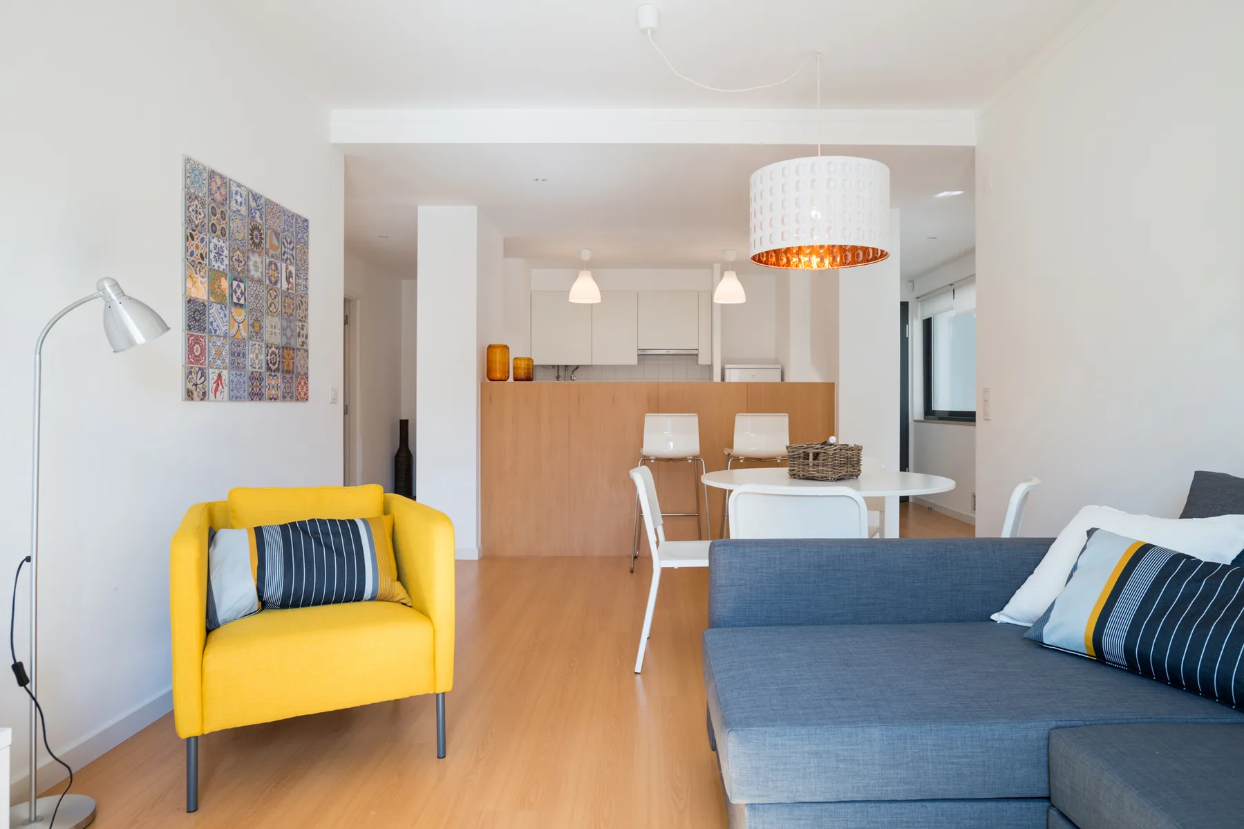 Una luminosa sala de estar con asientos y una cocina-comedor abierta.