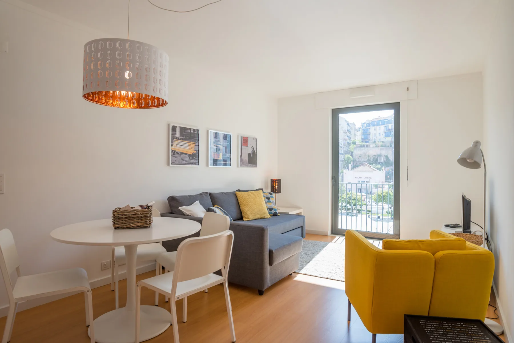 A bright living room with a dining table, seating, and a glass balcony door.