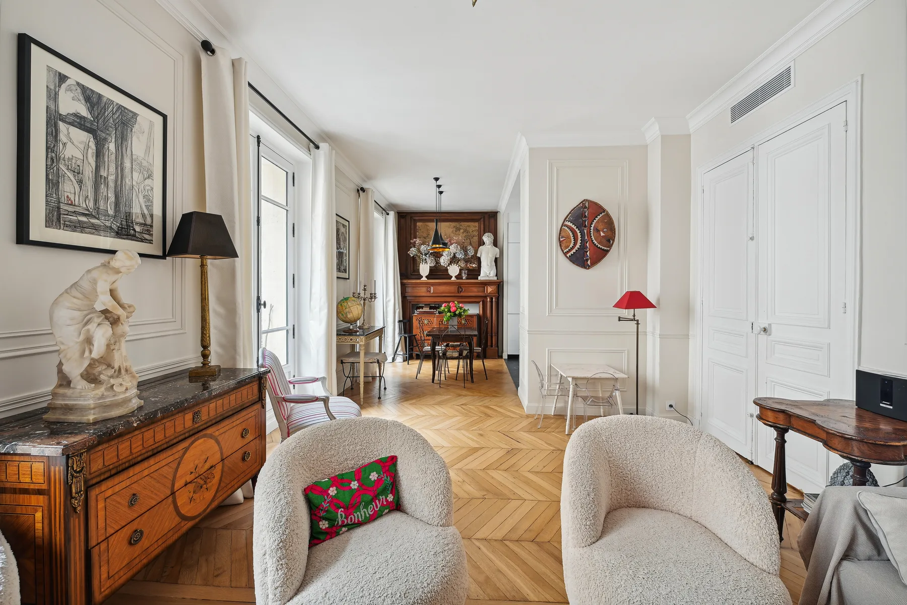 Una sala luminosa con asientos tapizados y un mueble de madera.