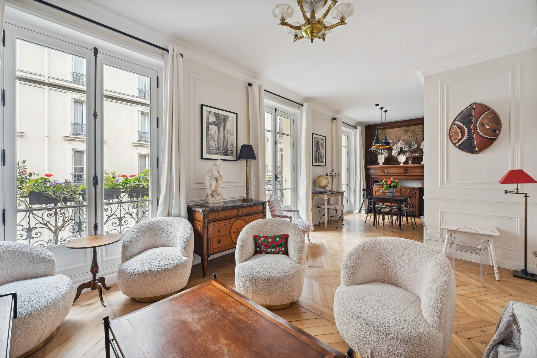 Una sala luminosa con asientos tapizados, ventanas altas y una mesa de centro de madera.