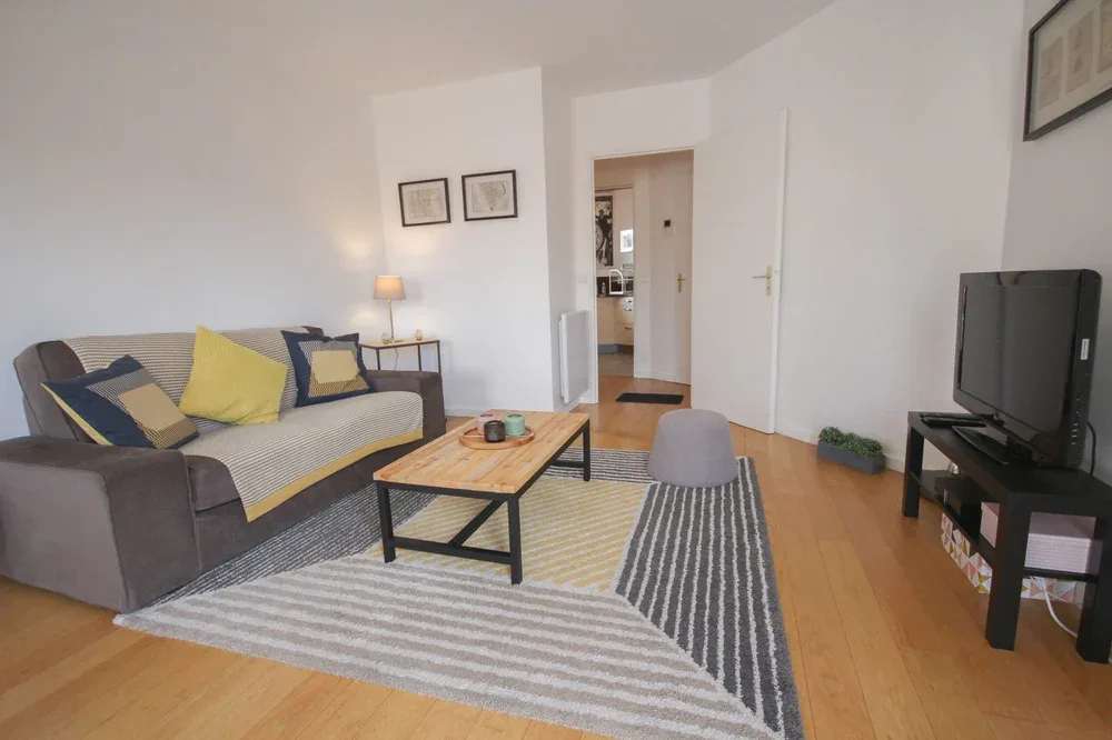 A living room with seating, a coffee table, and a television.