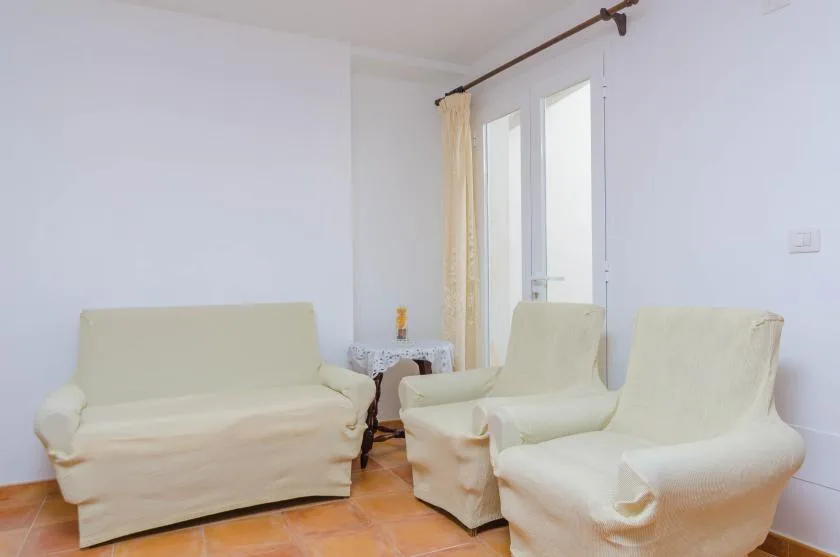 A living room with cream-colored seating beside a tall window.