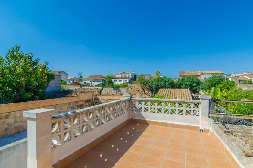 A tiled outdoor terrace overlooks nearby homes and greenery.