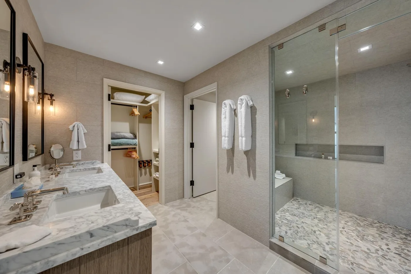 A bathroom with a double-sink vanity and a glass-enclosed shower.