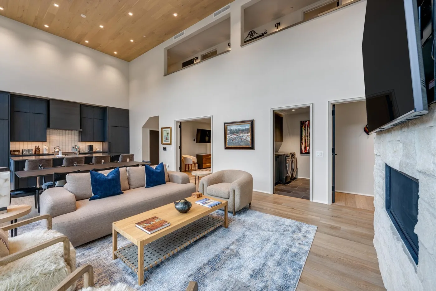 A bright living room with seating arranged around a coffee table and rug.