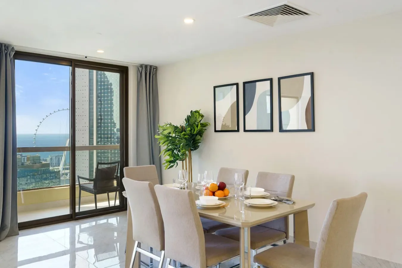 A dining area with a table and chairs beside large windows overlooking the water.