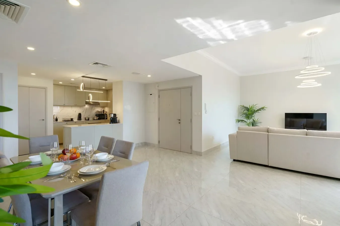 An open-plan living and dining area with a dining table and light-colored seating.