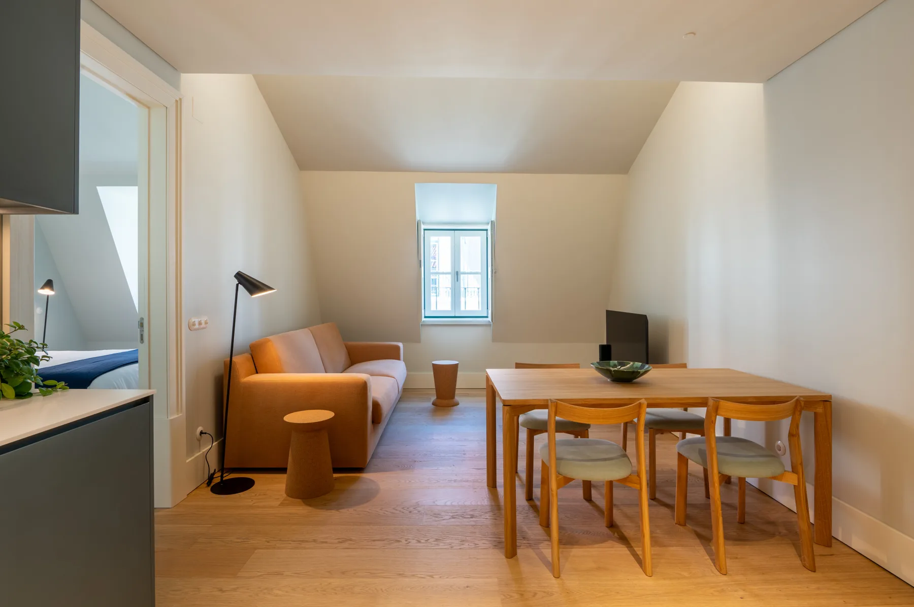 Una zona de estar y comedor con mesa, asientos y una ventana.