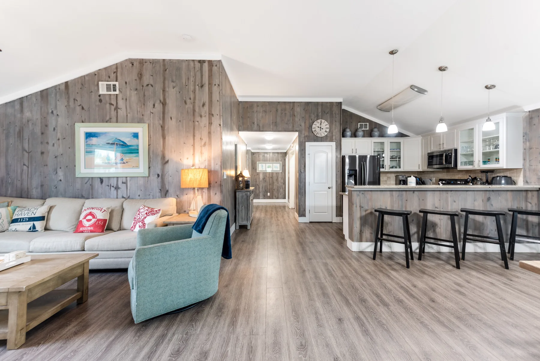 An open-plan living room and kitchen with a seating area and breakfast bar.
