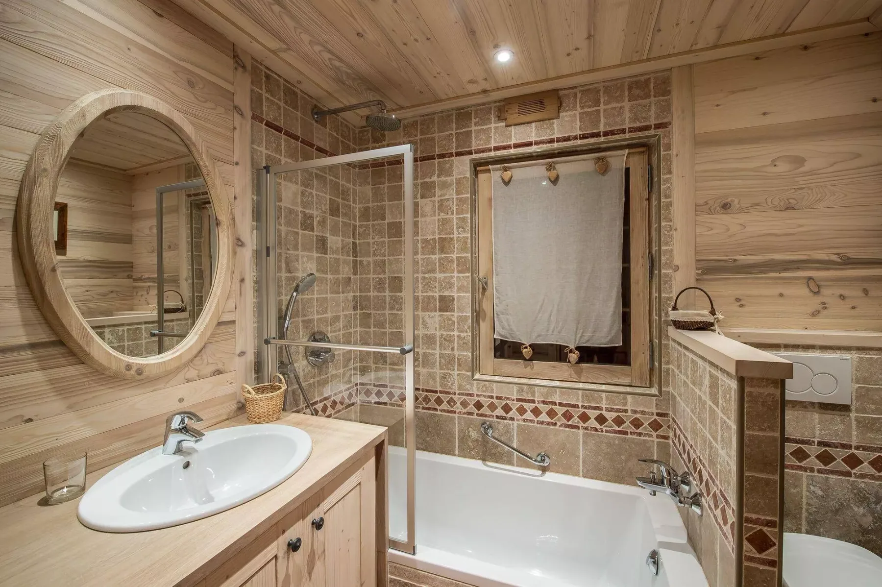 Un baño con azulejos cuenta con bañera, mampara de ducha y paredes revestidas de madera.