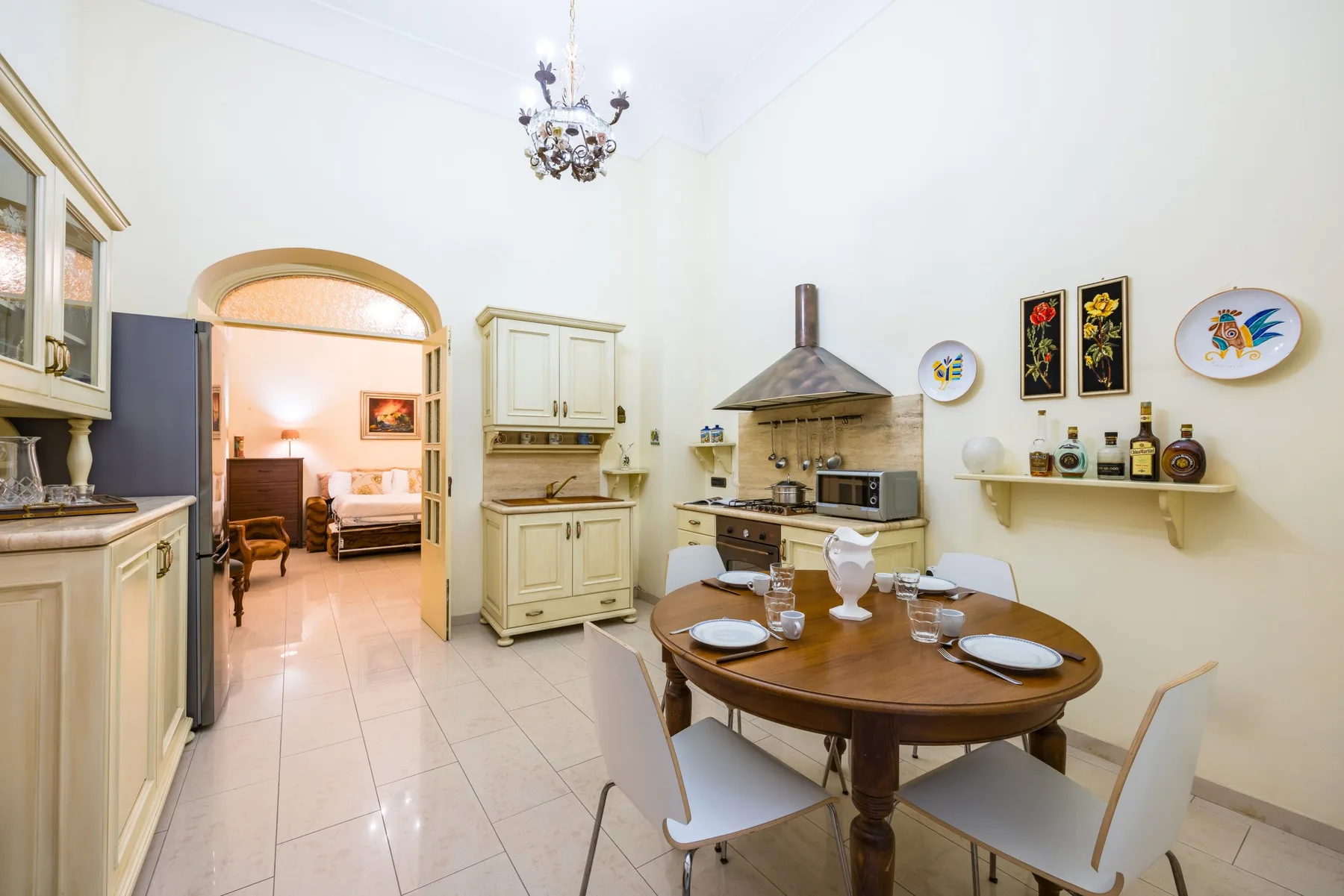 A bright kitchen and dining area with a round wooden table and cream cabinetry.