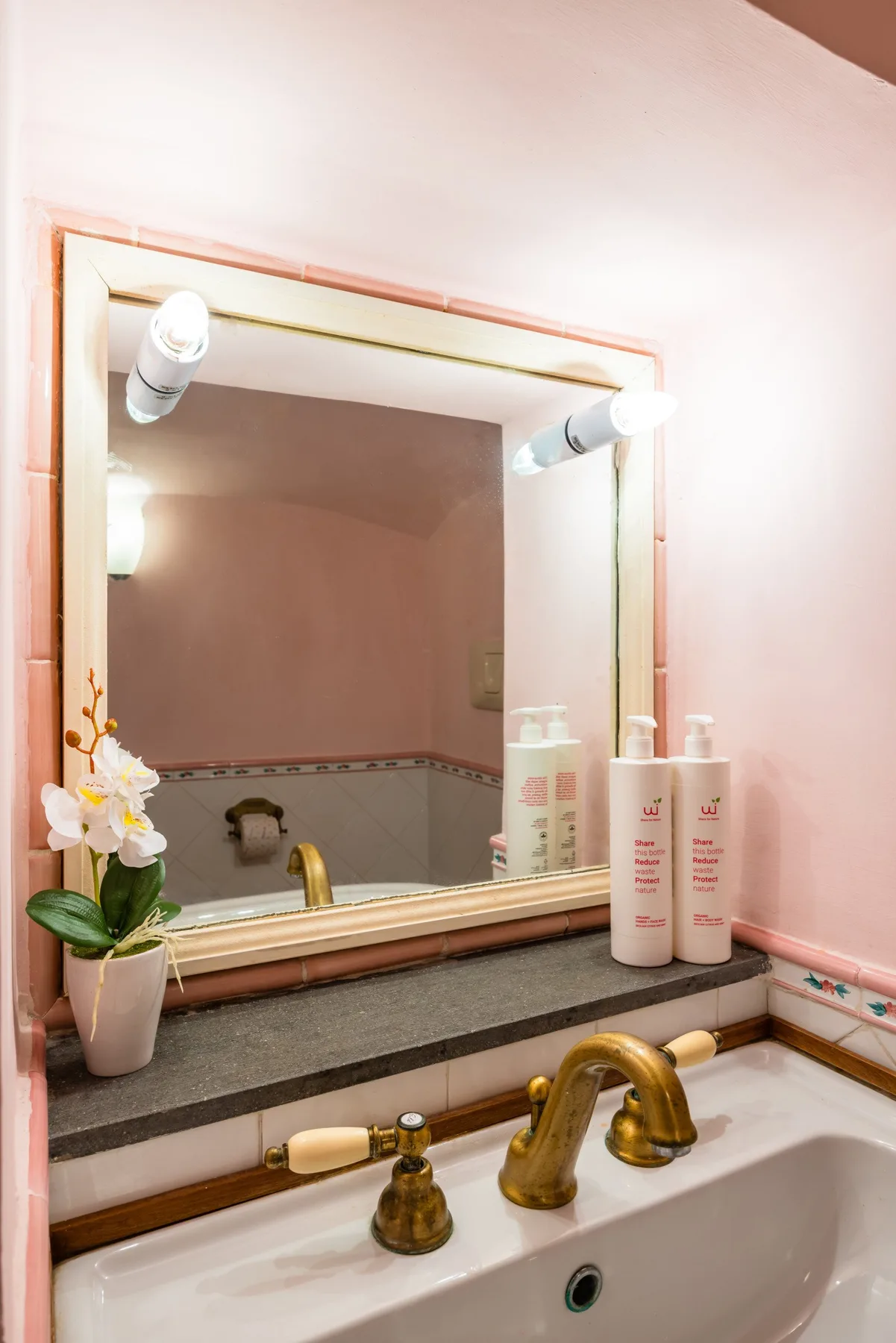 A bathroom vanity with a framed mirror, countertop, and sink.