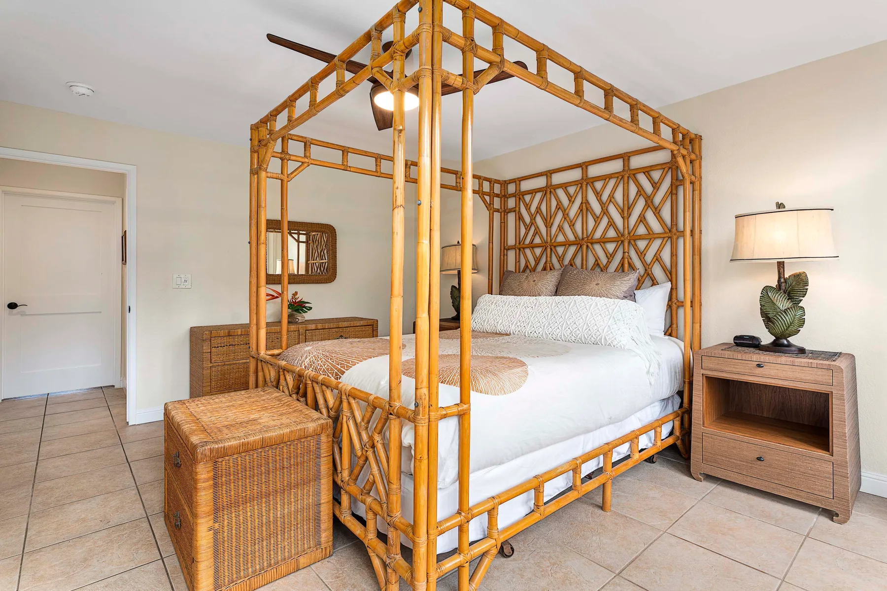 Un dormitorio con una cama blanca bajo una estructura de dosel de madera.