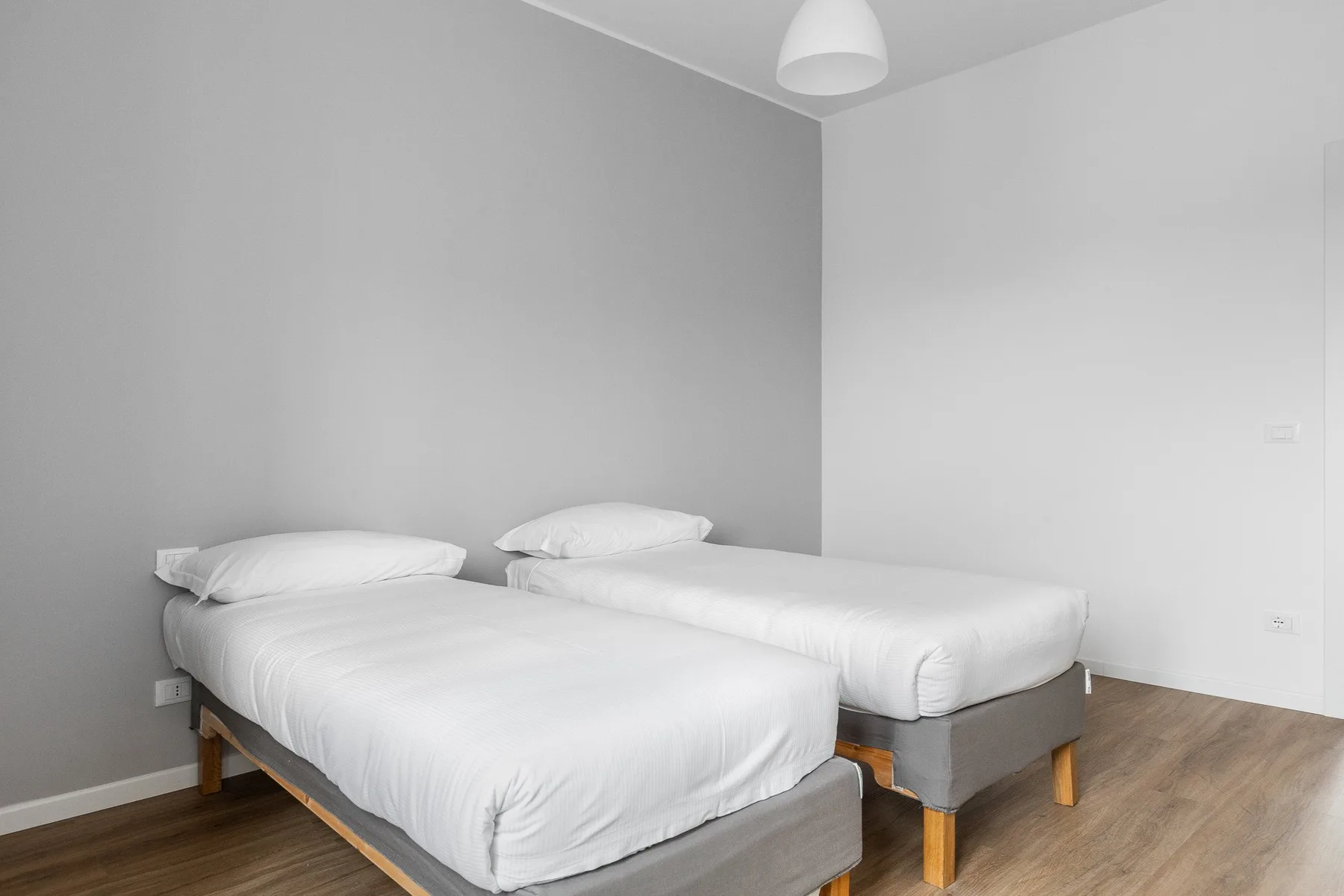 Un dormitorio con dos camas individuales y una lámpara colgante.