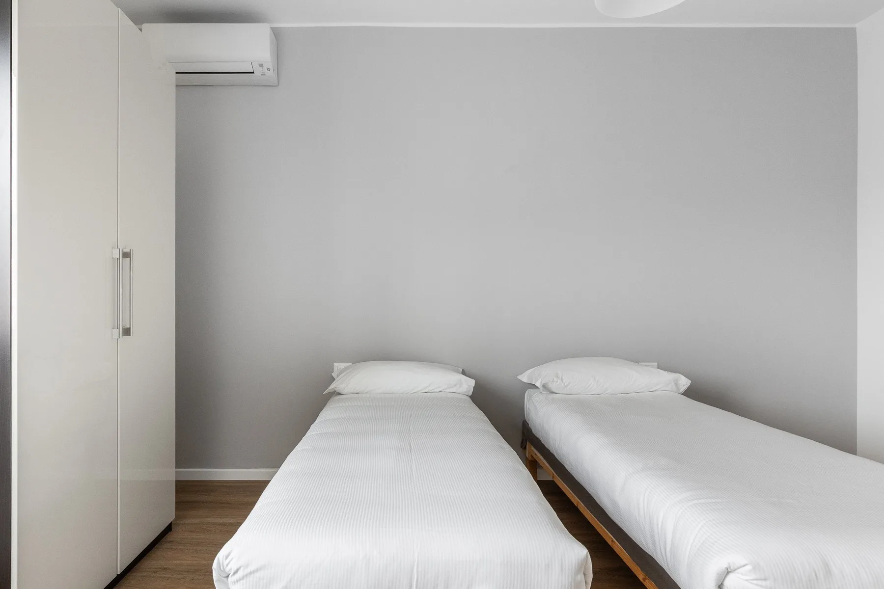 Un dormitorio con dos camas individuales y ropa de cama blanca.