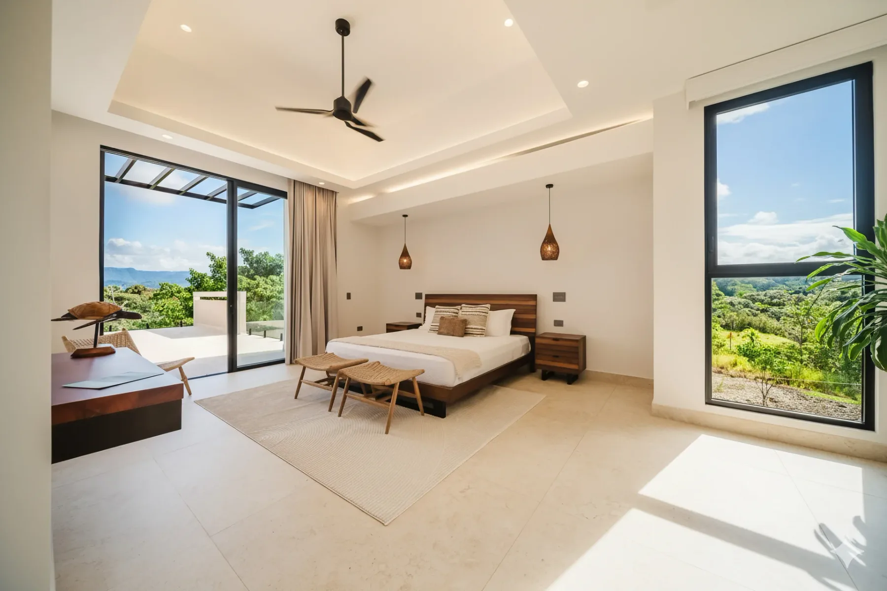 Casa Ama · 15. This bright bedroom features a king-size bed, a tray ceiling, and natural light from large sliding doors leading to a terrace and a window with views of tropical hills.