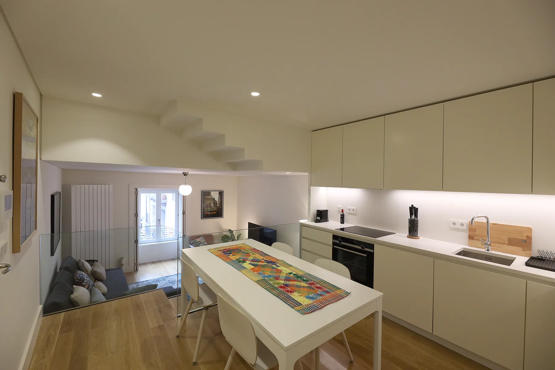 Una cocina abierta al salón con una mesa de comedor y asientos.