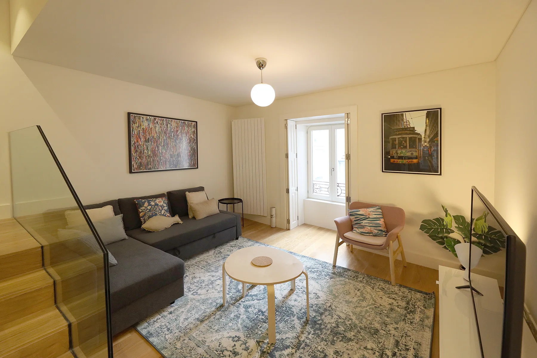 A living room with seating, a rug, and a bright window.