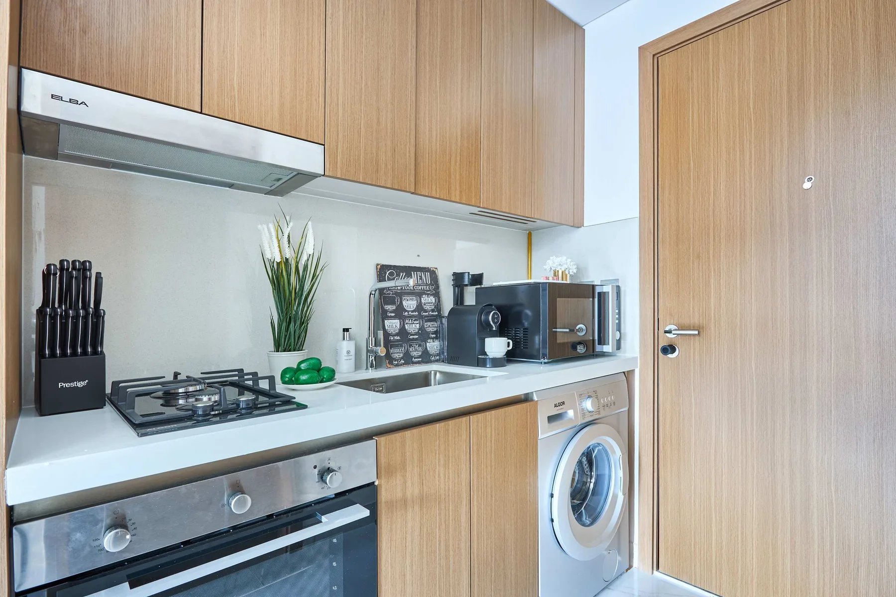 Una cocina moderna con gabinetes de madera, una estufa y electrodomésticos sobre la encimera.