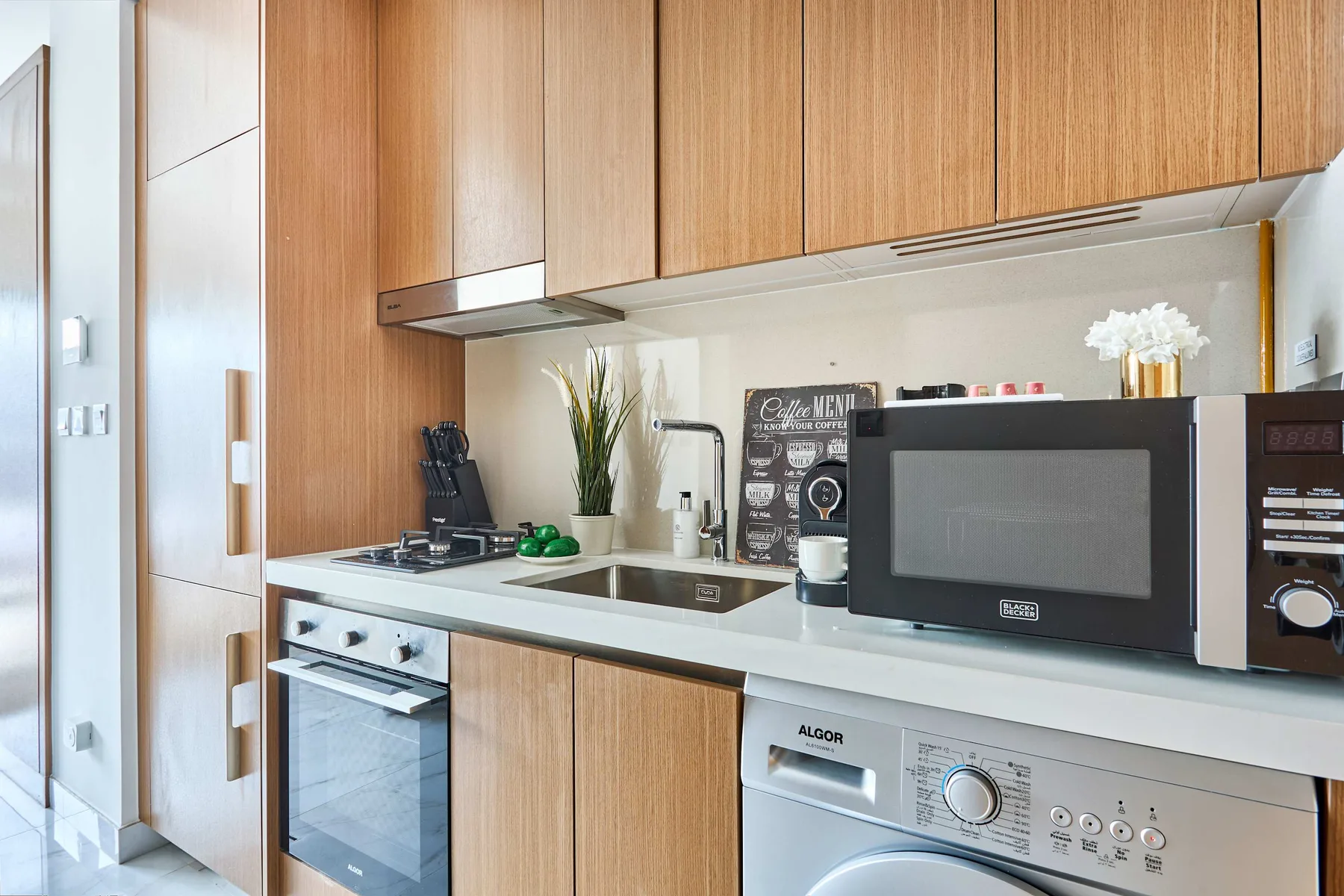 Una cocina moderna con armarios de madera, encimera y electrodomésticos integrados.