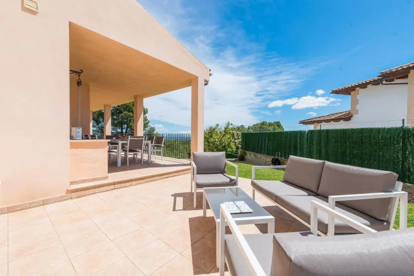 Un patio al aire libre con asientos de descanso y una zona de comedor cubierta.