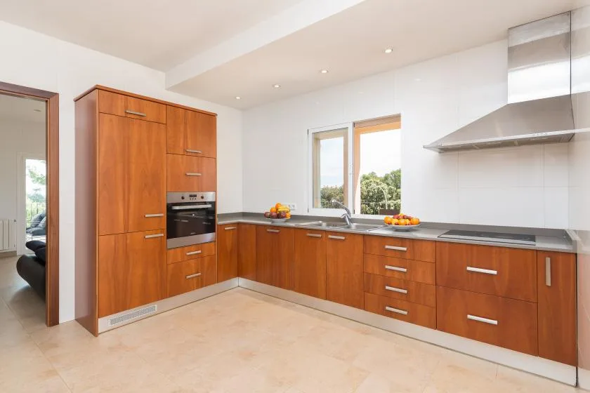 Una cocina moderna y luminosa con armarios de madera y una amplia encimera.