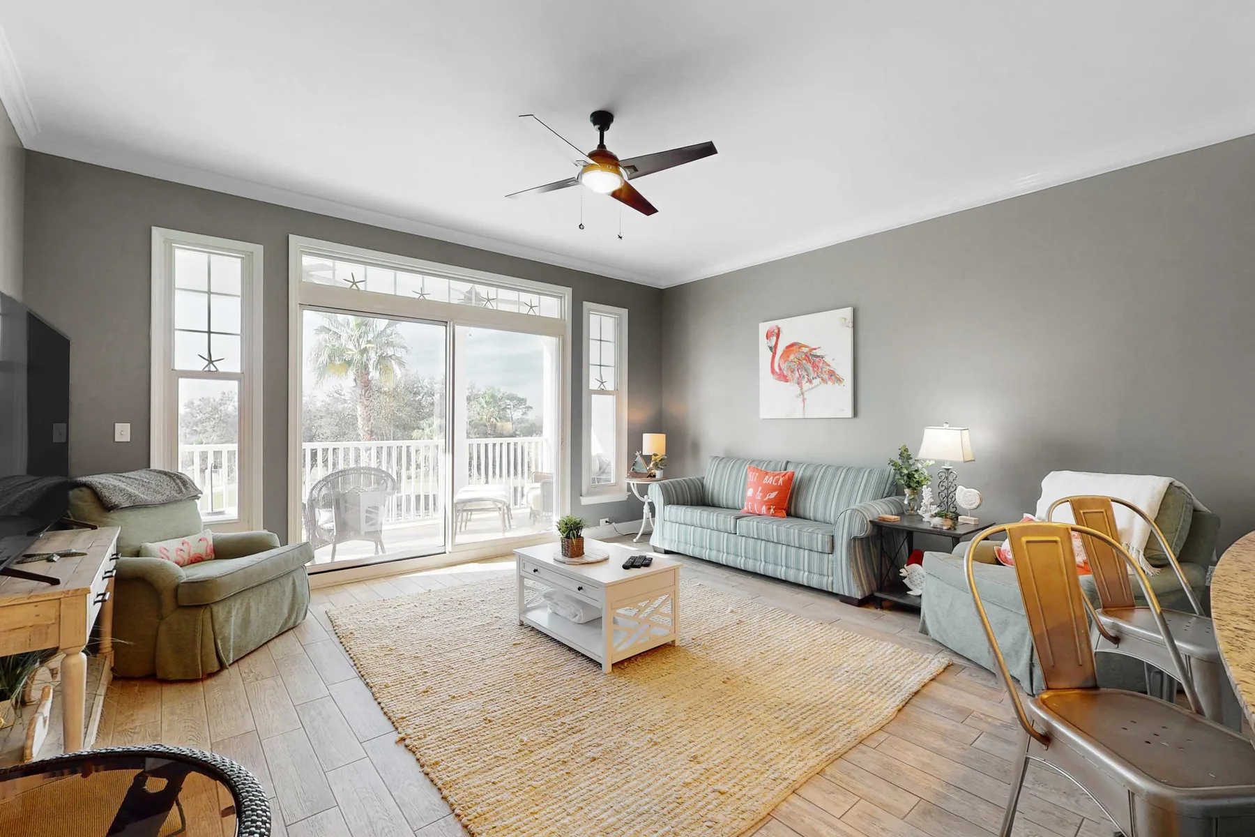 A bright living room with seating around a coffee table and large windows.