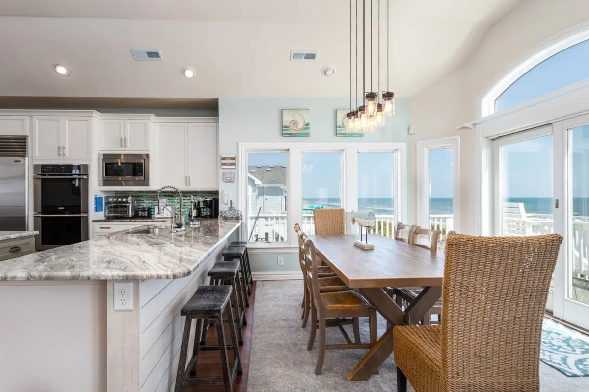 An open kitchen and dining area with large windows overlooking the water.