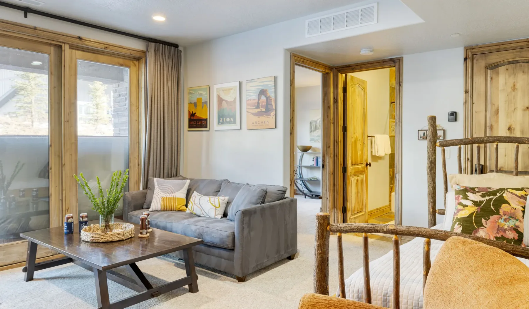 A living room with seating, a coffee table, and glass doors.