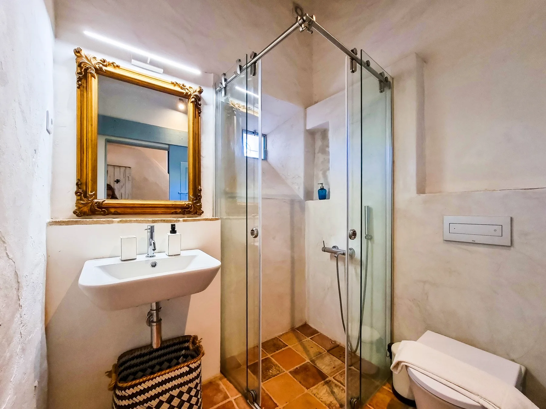 Un baño con lavabo, ducha e inodoro.