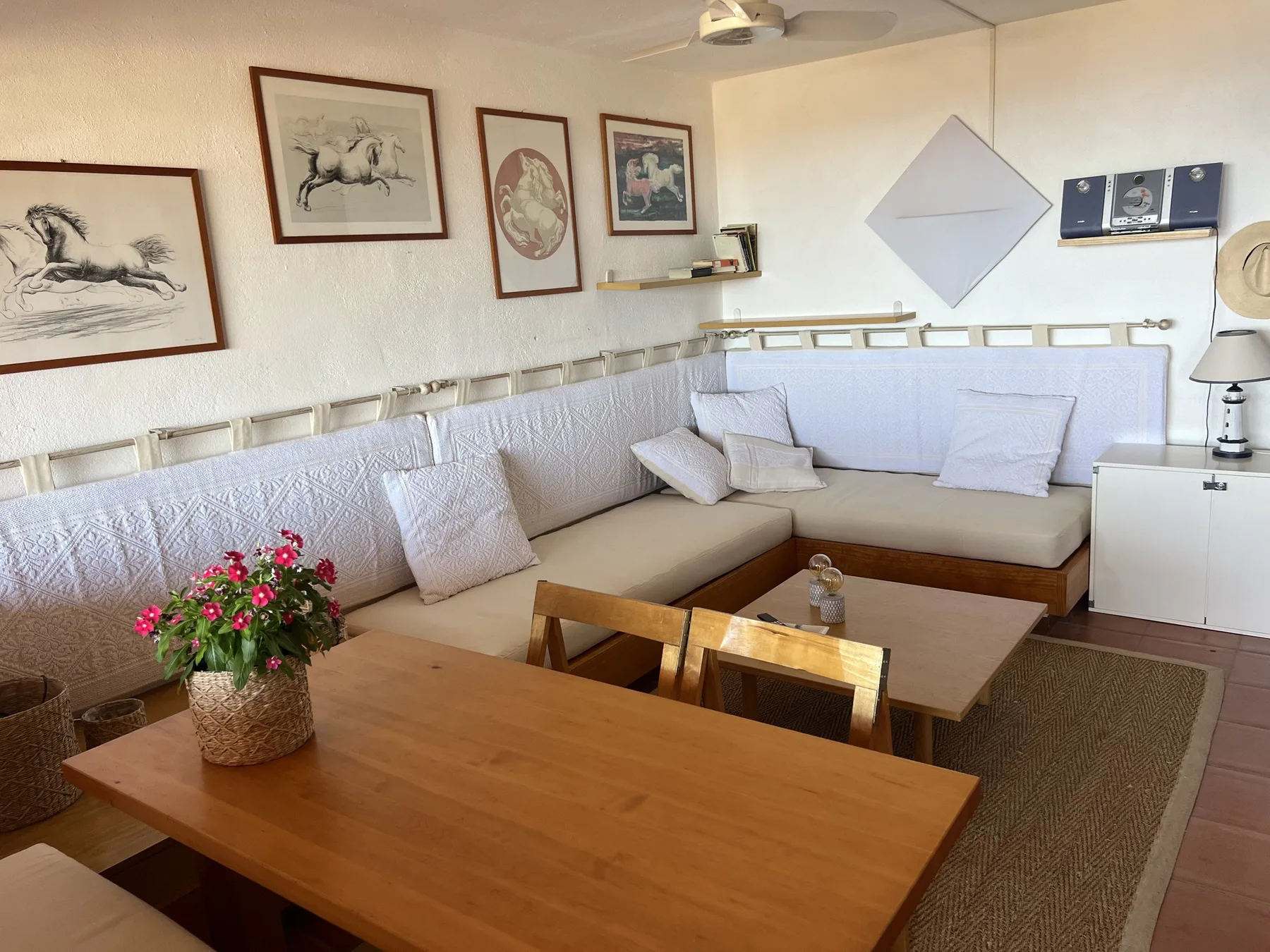 Una sala de estar y comedor con un amplio asiento en forma de L y una mesa de madera.