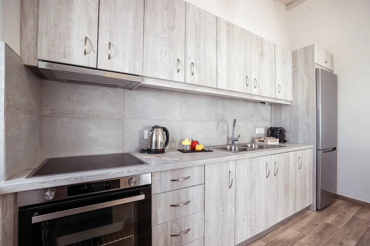 A modern kitchen with pale cabinets and a countertop.