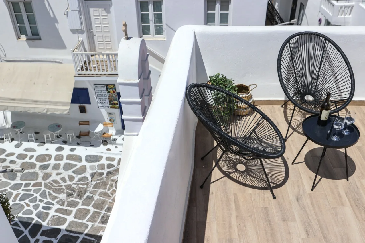 A small terrace with black wire seating and a round side table.