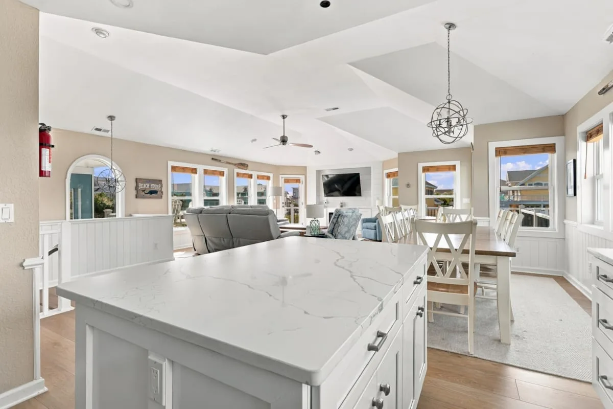A bright open-plan kitchen and dining area with a large island and dining table.