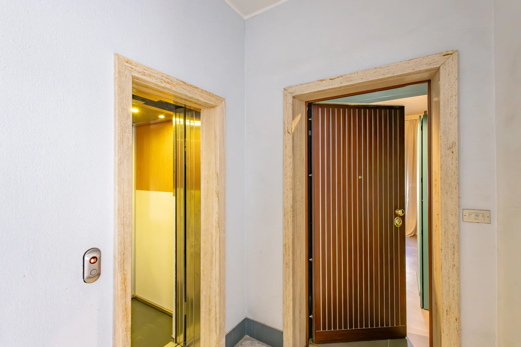 An elevator and a doorway with a dark slatted door are visible in a hallway.