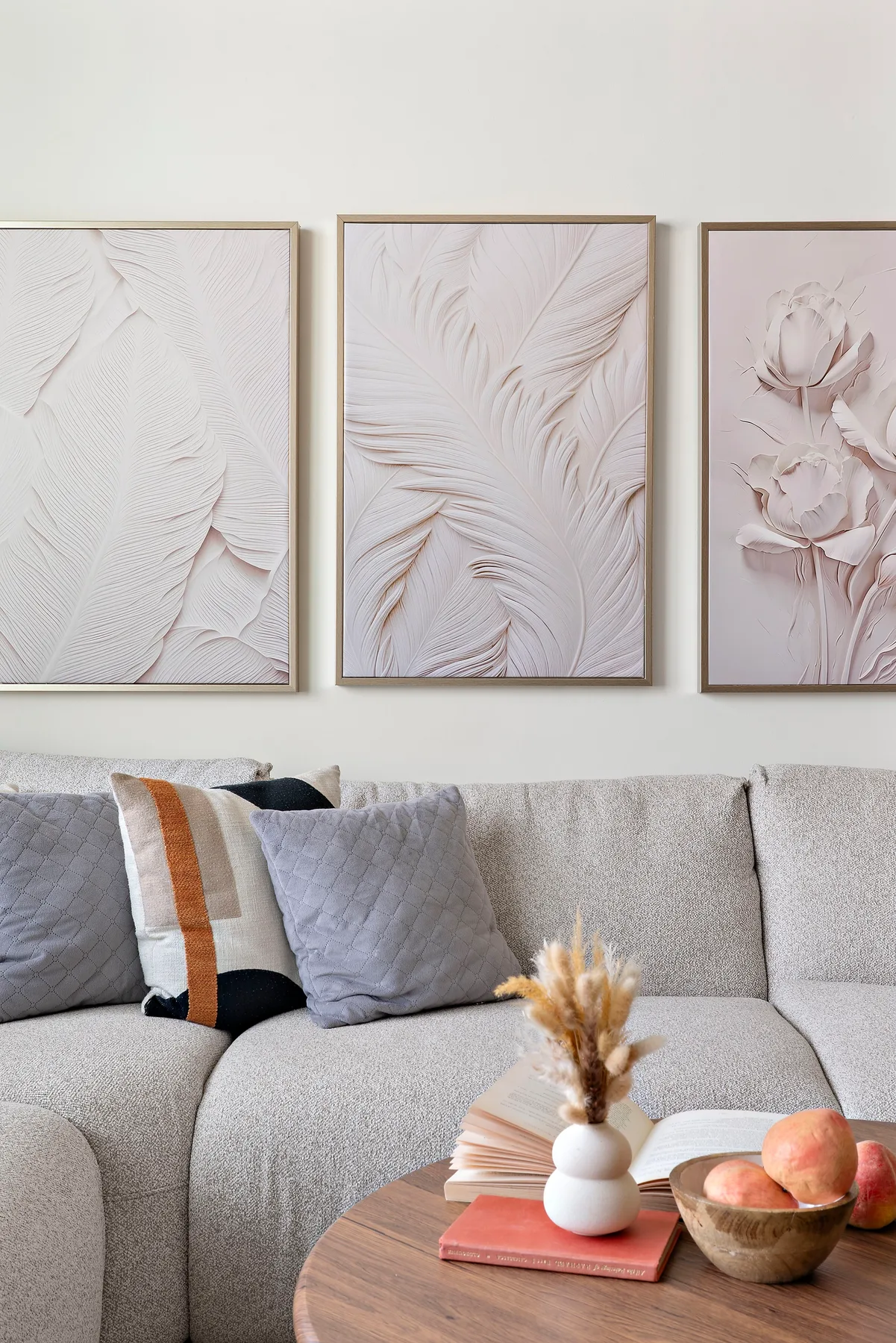 A living room with a gray sofa, framed artwork, and a wooden coffee table.