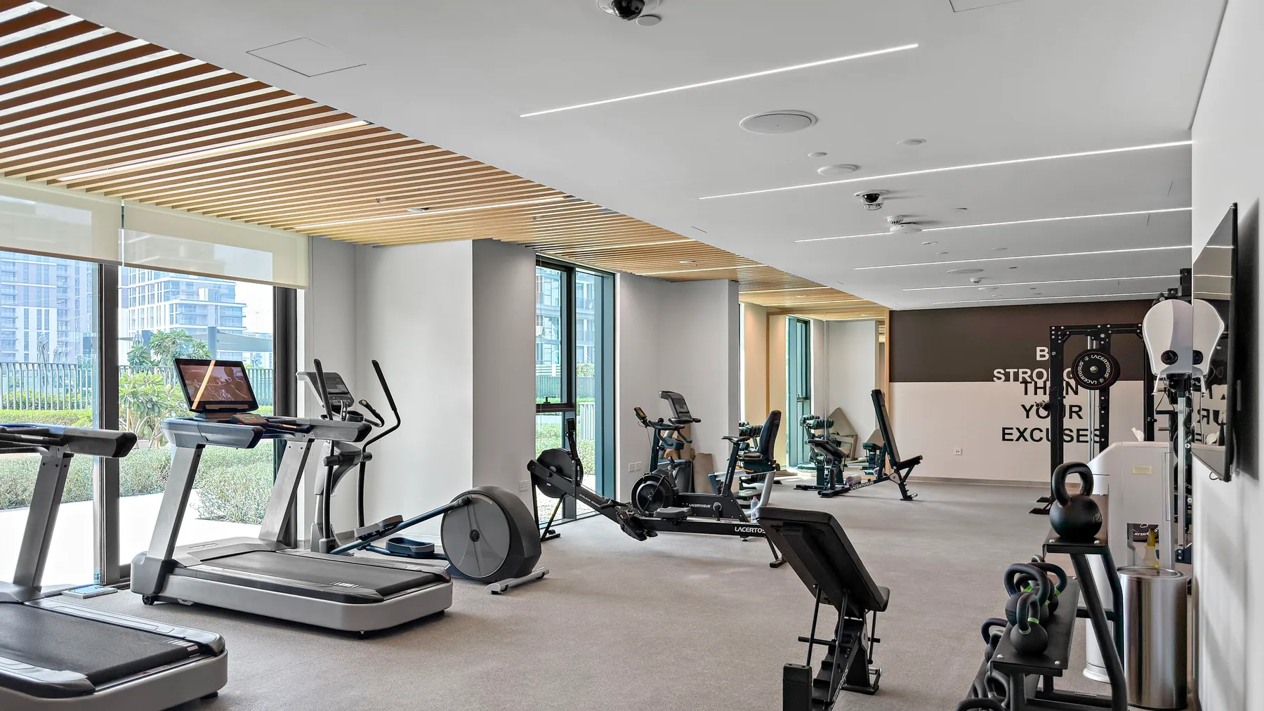 A modern gym with exercise machines and large windows.