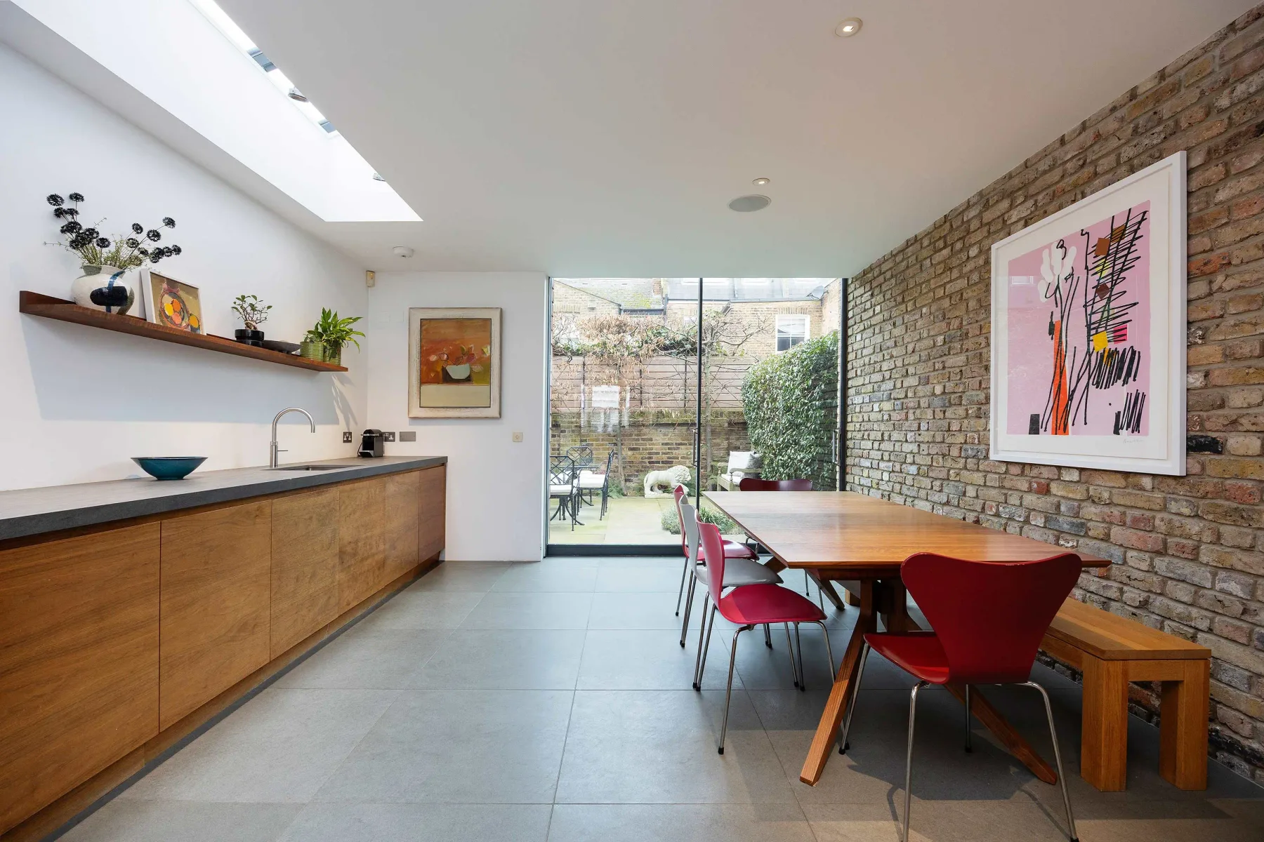 Una cocina y comedor luminosos se abren al jardín a través de puertas de vidrio.