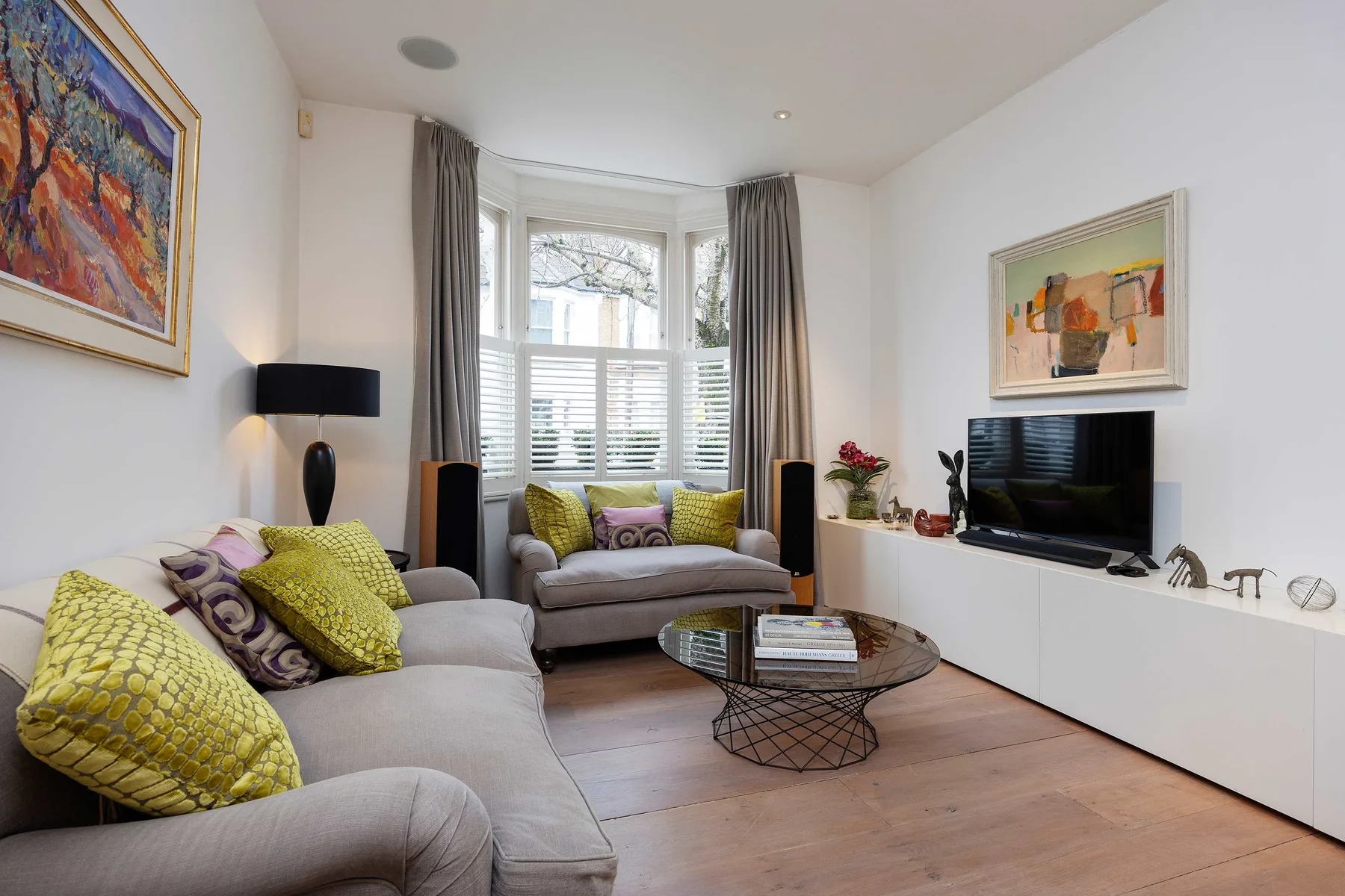 Una sala luminosa con asientos, un televisor y una ventana mirador.