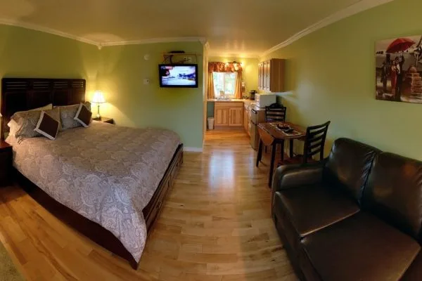 Suite interior with king bed, seating area and desk