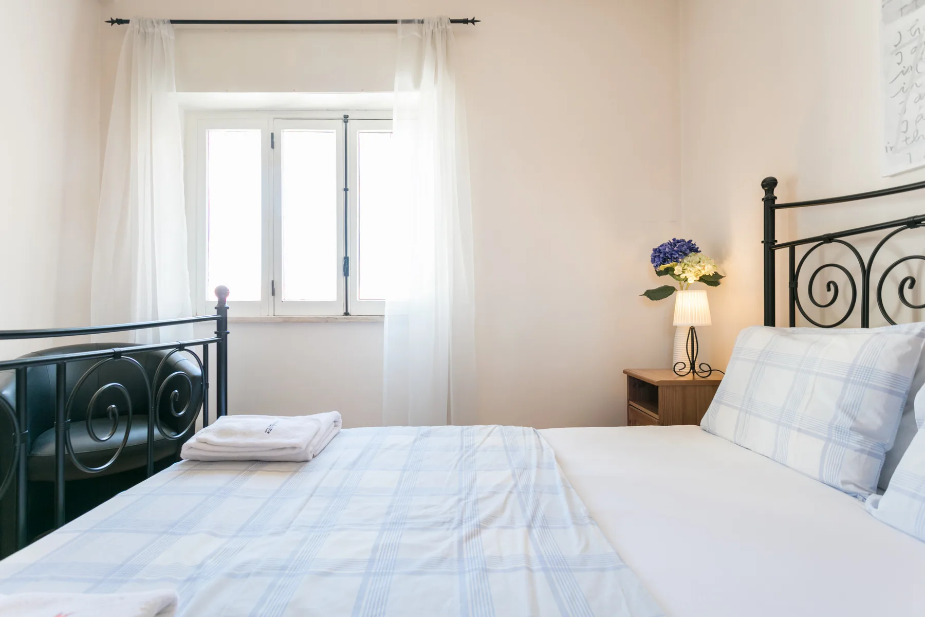 Un dormitorio con una cama junto a una ventana luminosa.