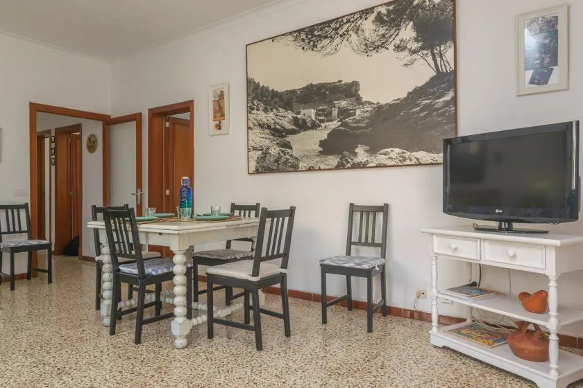 Comedor con una mesa y sillas junto a un televisor.