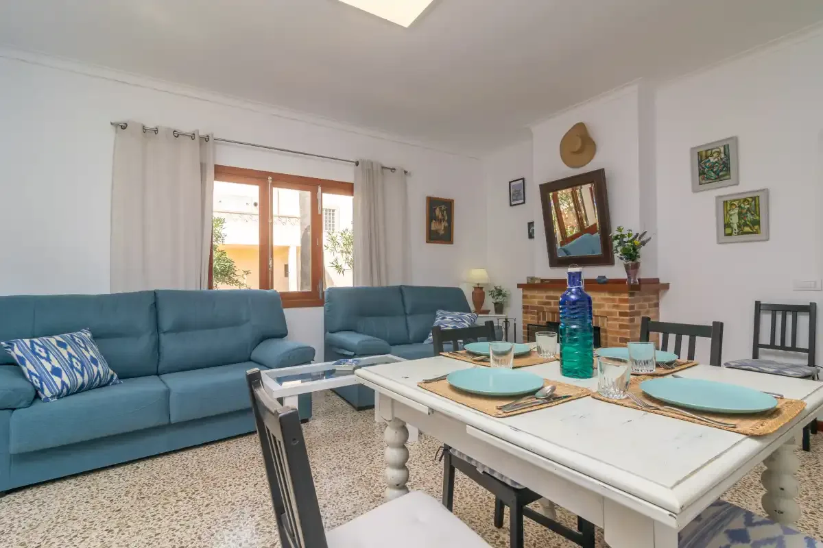 Sala de estar y comedor con asientos azules y una mesa puesta.