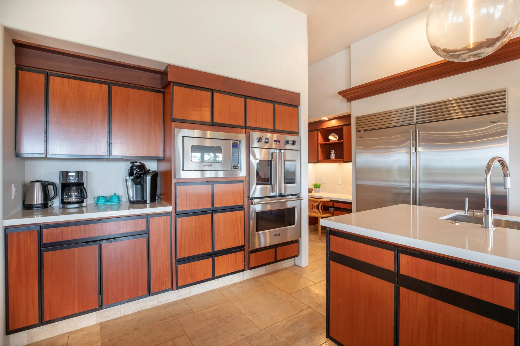 Una cocina moderna con gabinetes de madera, electrodomésticos de acero inoxidable y una isla central.