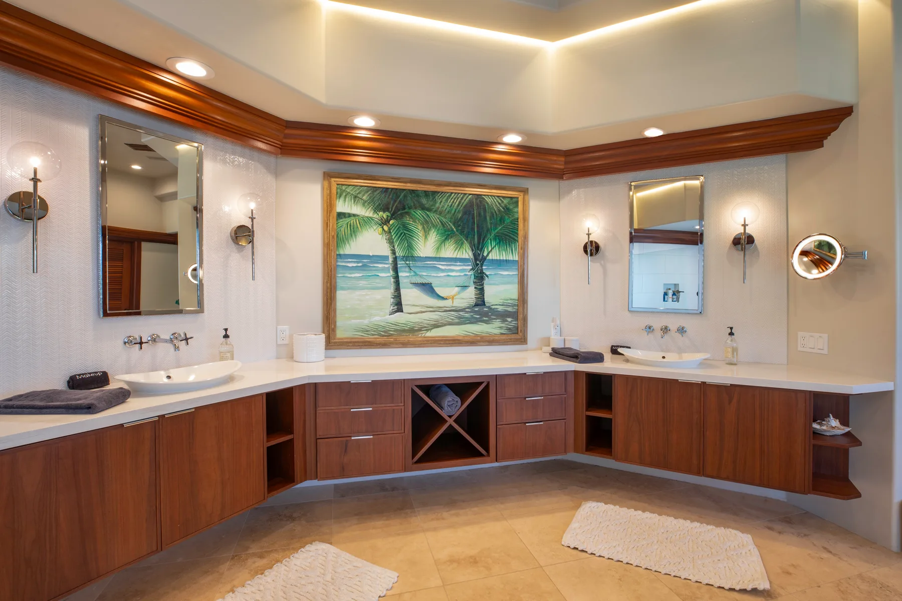 Un tocador de baño recorre la habitación bajo una imagen enmarcada de una playa tropical.