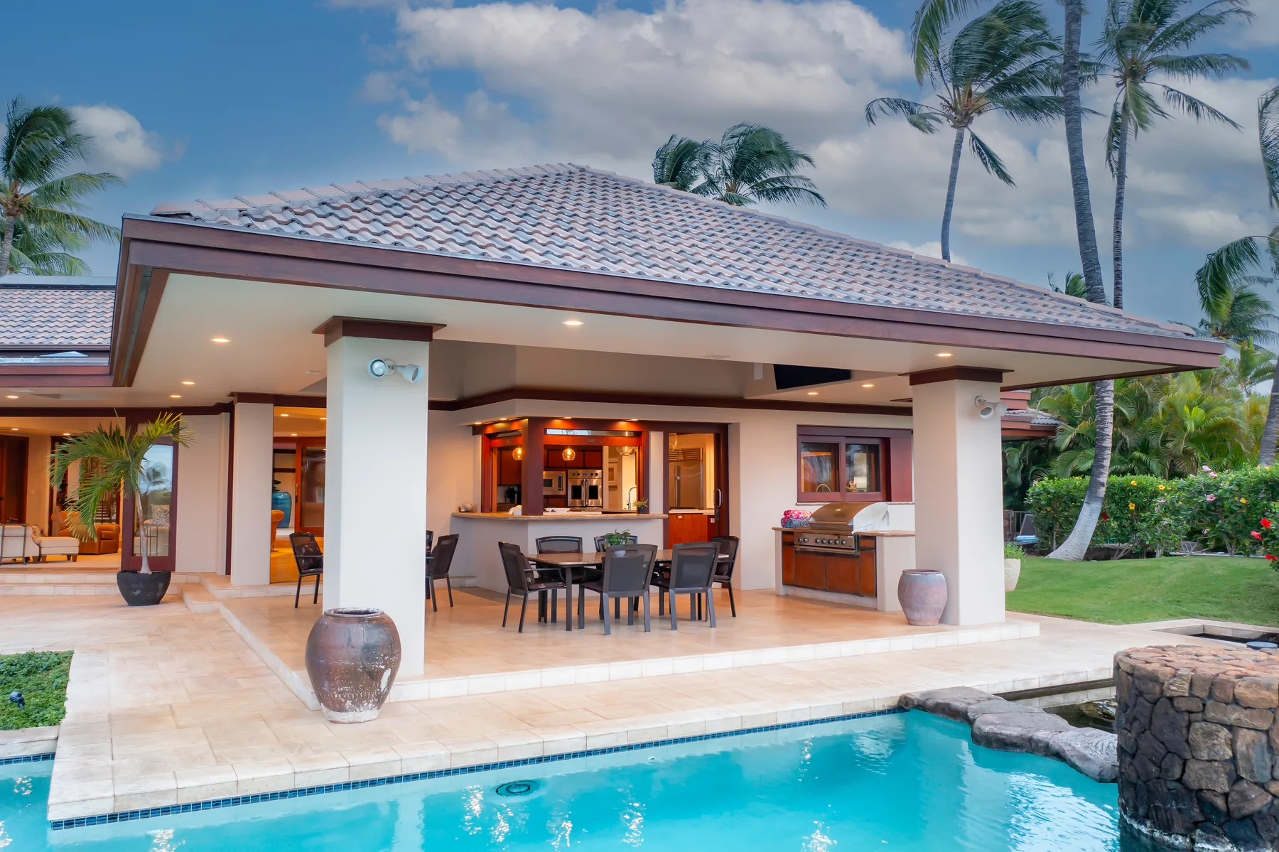 Un patio al aire libre con una mesa de comedor está junto a una piscina.